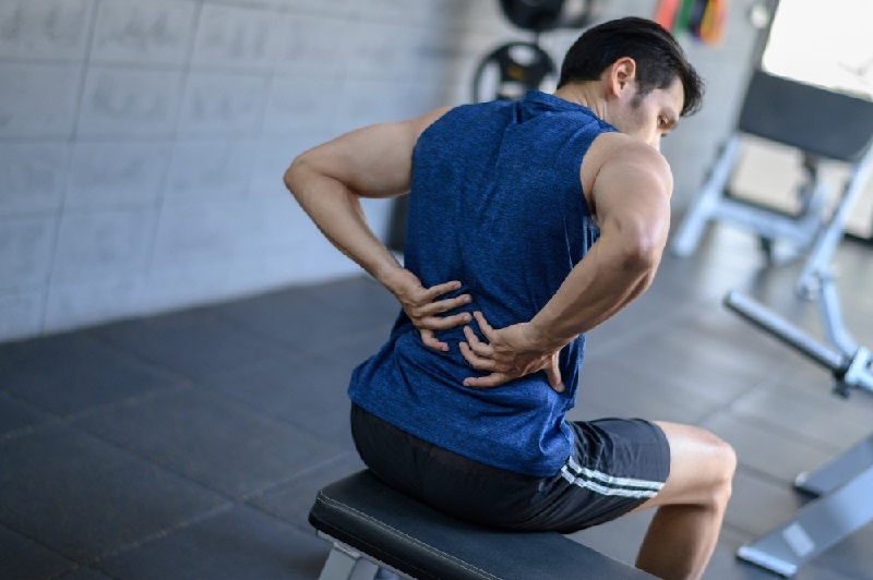 Máy mát xa lưng giá bao nhiêu - người luyện tập thể thao bị đau lưng cần máy mát xa lưng thư giãn